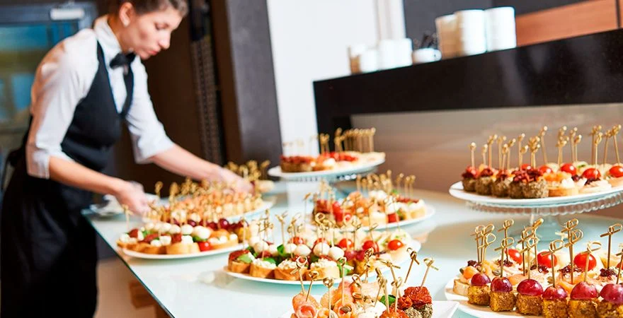 Montaje de banquetería con mesas servidas y decoración elegante