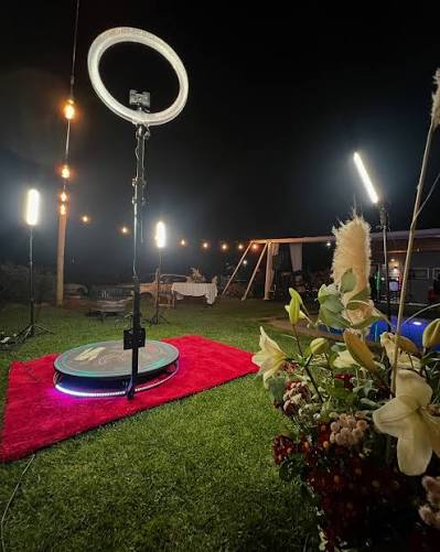 Invitados usando cabina fotográfica y plataforma 360 en evento