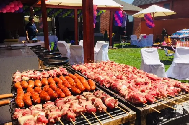 Asado a domicilio para evento al aire libre con parrilla encendida