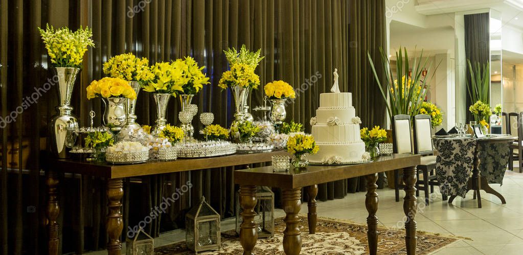 Torta de matrimonio decorada junto a mesa de postres iluminada
