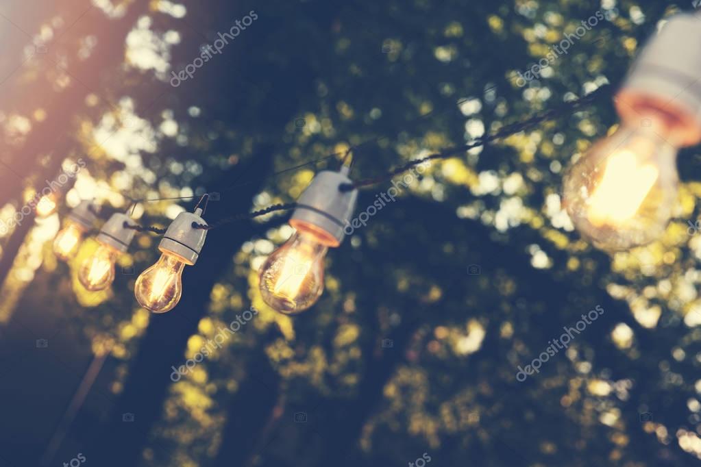 Evento al aire libre con guirnaldas de luces y mesas decoradas
